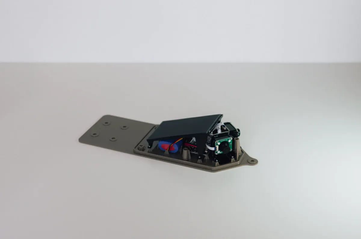 Solar waterproof camera with the enclosure open, showing the solar panel lid, battery and ESP32 camera board