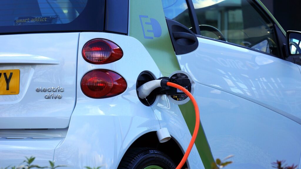 Electric car plugged into a charging station in a parking bay